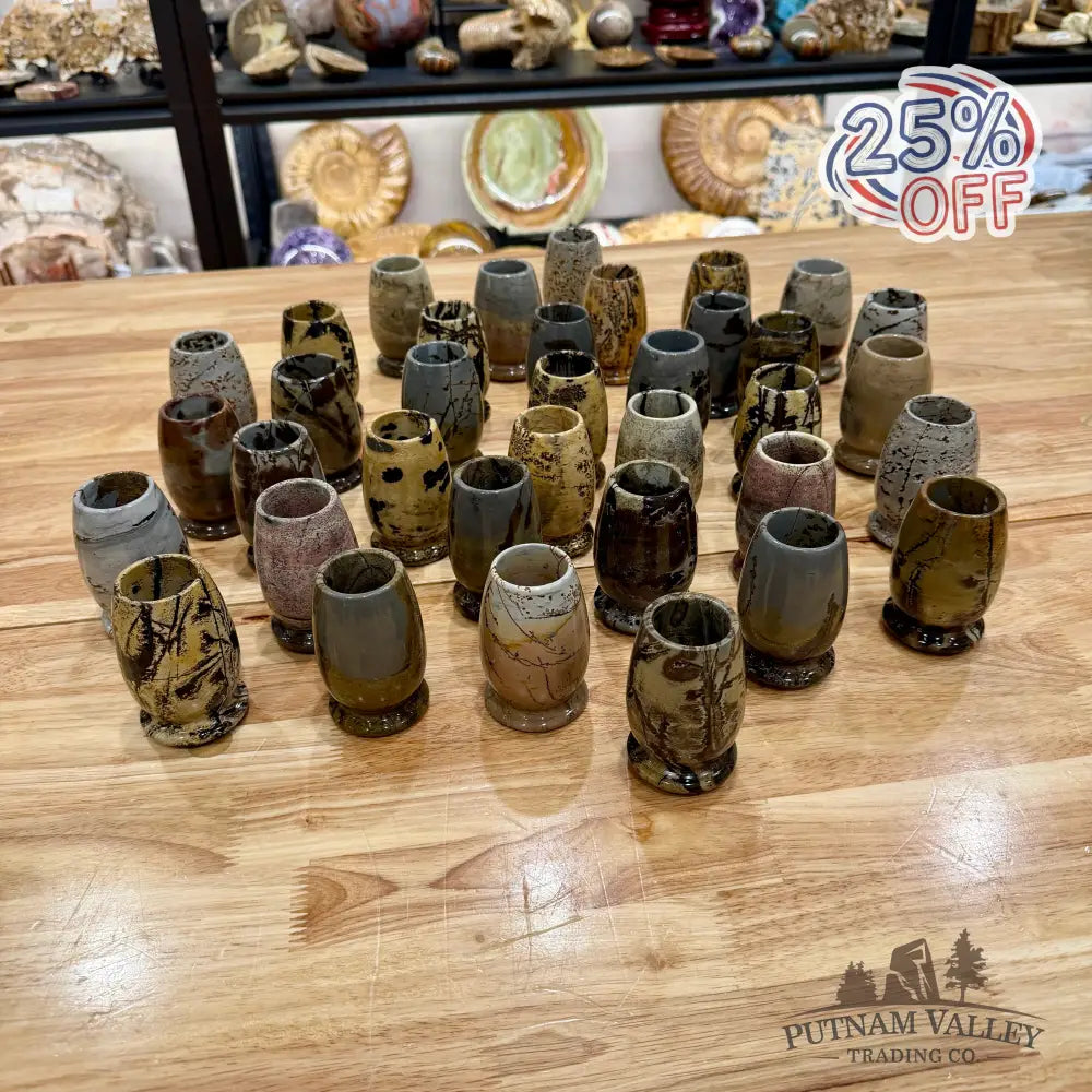 Collection of stone cups on a wooden table with shelves in the background