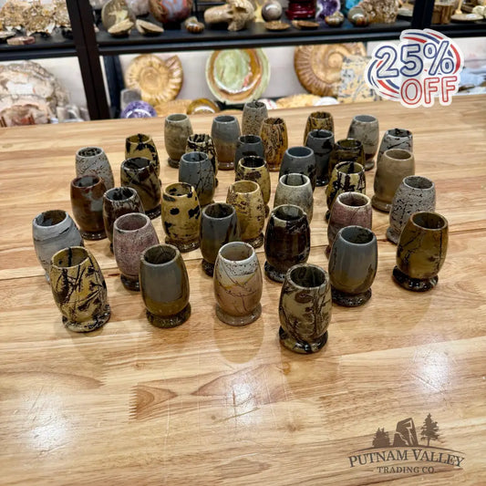 Collection of stone cups on a wooden table with shelves in the background